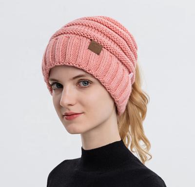 China RTS COMMON Custom Soft Stretch Tail Winter Cable Knit Messy Hole Hat High Bun Ponytail Beanie For Women for sale