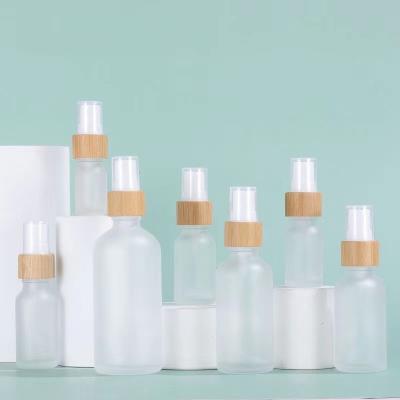 China 5ml-100ml cosmetic frosted empty glass essential oil spray bottle with natural wooden bamboo pump for sale