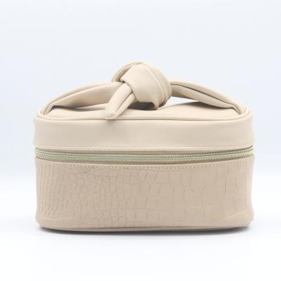 China Fashion Sandy Beige PU Water Based Cosmetic Pouch Untie Bowknot Perfectly Handle Pale Class Alligator Pattern Waterproof PU Toiletry Bag for sale