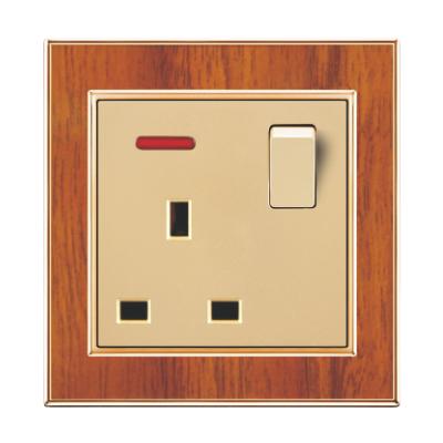 China UK Standard Competitive Price UK Standard Wiring Accessories Wood Grain With Gold Plating Frame 13A Switched Socket With Neon for sale