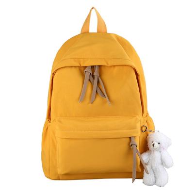 China Trendy Fashion Solid Color Canvas Backpack High School College Casual School Bag Waterproof With Cartoon Charm for sale