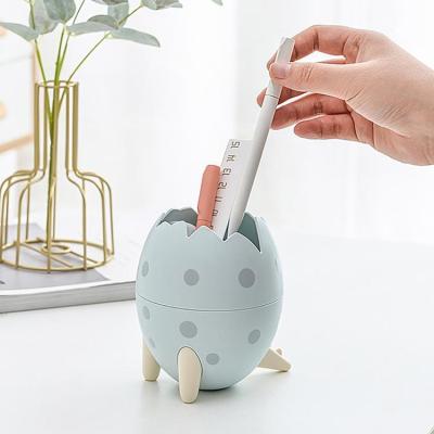 China New Fashionable Dinosaur Cartoon Egg Shape Storage Box Desktop Student Stationery Sundries Tube Pen Holder for sale