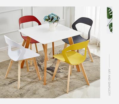 China Export colorful bestselling modern simplicity plastic dining chairs with wooden legs for sale