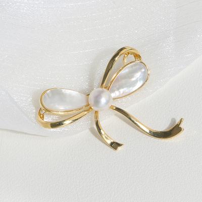 China 2020 fashion hot sale popular style gold plated bowknot brooch freshwater button pearl brooch women jewelry for sale