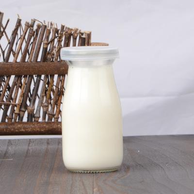 China Sustainable Round Bottom Empty Milk Juice Tea Water Soft Empty Drinking Bottle Glass With Screw Lid for sale