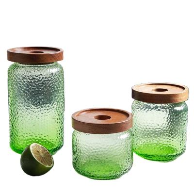 China Customized wholesale transparent home 500ml cookie candy tea sealed cans hammer pattern storage jar green glass with bamboo lid for sale