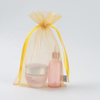 China Recyclable Luxury Orange Organza Drawstring Bag Skin Care Products Cosmetic Packaging Bag for sale