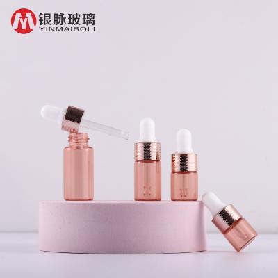 China Small Pink Personal Care Gold Color Sample Dropper Glass Bottle Bottle Vials With Pink Gold Honeycomb Ring Dropper Cap for sale