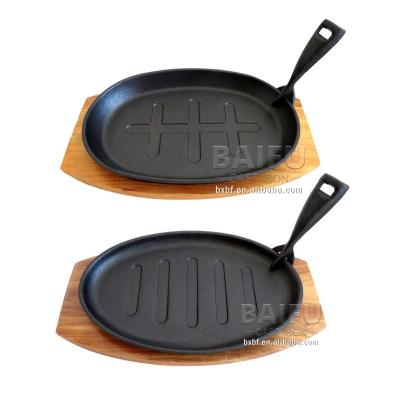 China Pre-Seasoned Cast Iron Steak Casserole Sustainable With Cookware Set Cast Iron Fajita Base Wooden Cast Iron Sizzling Casserole Dish for sale