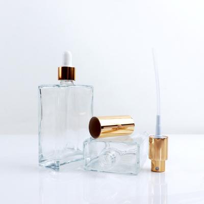 China Luxury Cosmetic Container 30ml 50ml Makeup Set Square Shape Clear Perfume Glass Serum Bottles With Gold Dropper Cap for sale