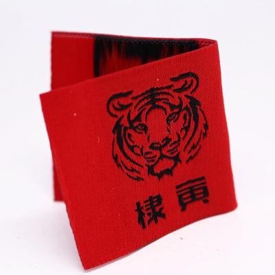 China Viable Red Logo On Black Bottom Woven Patches For Men's Red Bottom Woven Pattern Black Label Folded Edge Clothing Label for sale