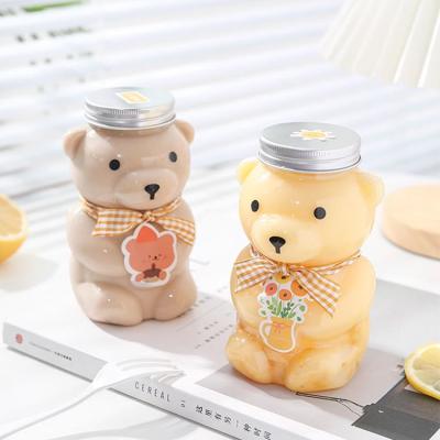 China Jugo de plástico Botella de té de leche con tapa en forma de oso reutilizable en venta