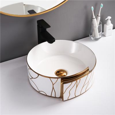 China Modern Luxury Design Art Wash Basin Hotel Round White And Gold Bathroom Vanity Sink Ceramic Basin For Dining Room for sale