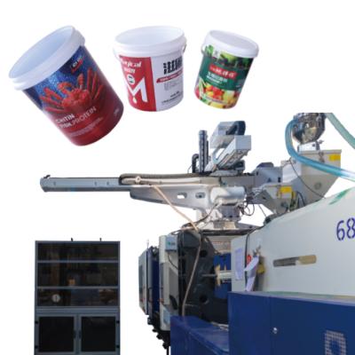 China Food Top Entry Type IML Robot Labeling Machine For Plastic Bucket Packaging for sale